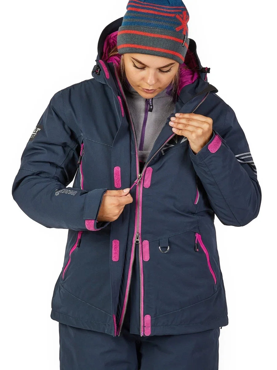 Woman zipping up navy blue winter jacket with pink accents, ideal for ice fishing or cold-weather outdoor adventures.