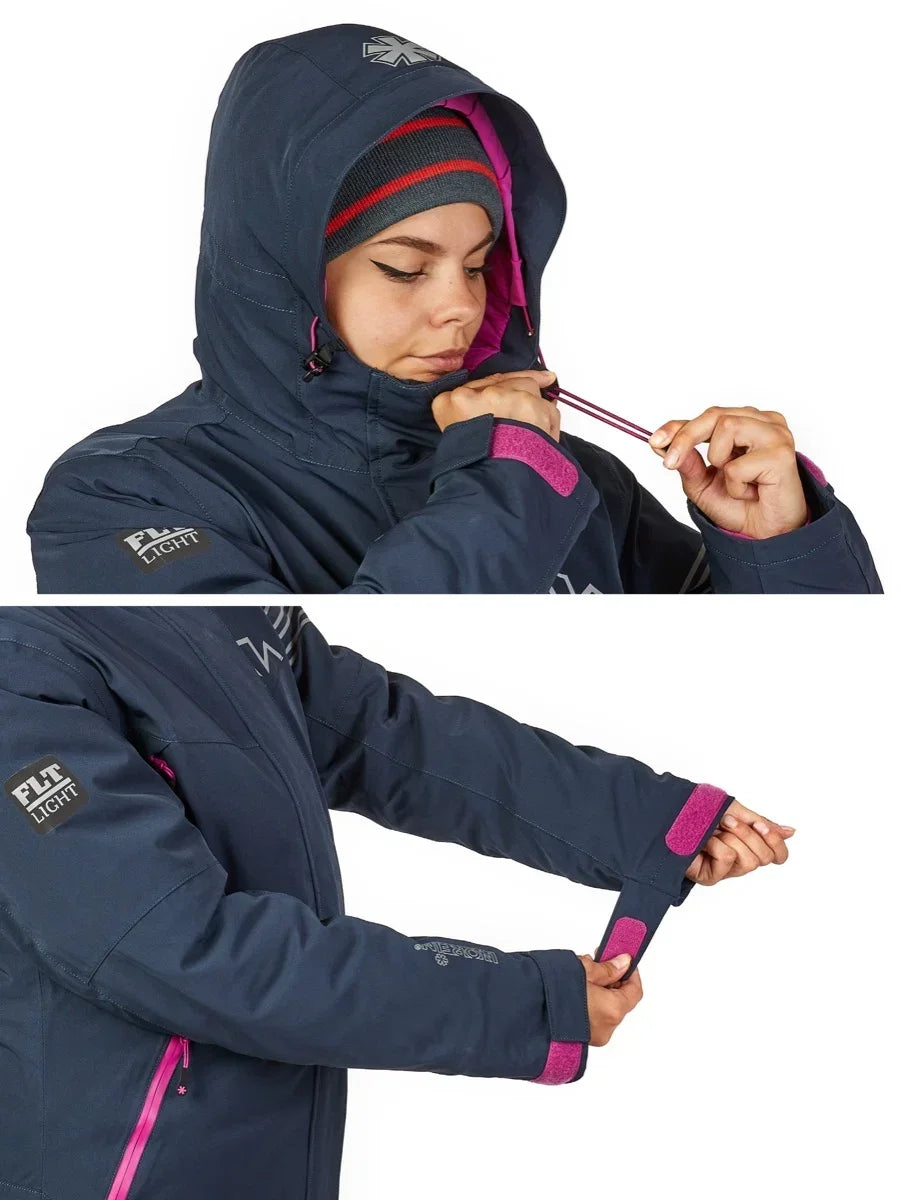 Woman adjusting hood and cuffs on navy blue waterproof jacket with pink accents, ideal for ice fishing or outdoor adventures