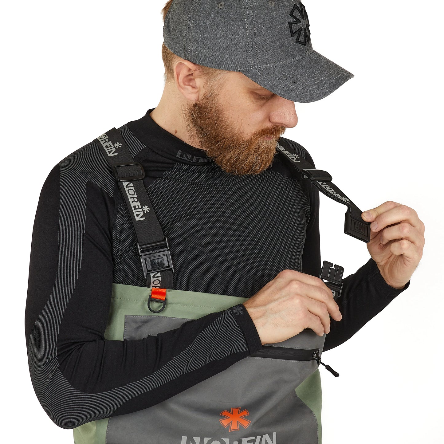 Man adjusting Norfin fishing bib with adjustable straps and orange accents for outdoor gear comfort