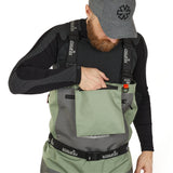 Man wearing olive and gray waterproof waders with chest pocket, ideal for ice fishing or outdoor adventures.